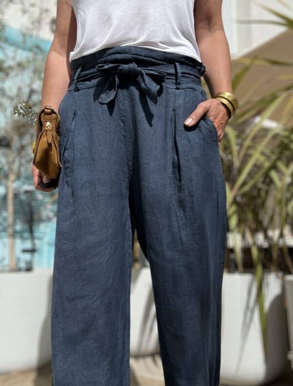 Pantalon Pierre en Lin Marine Confort, élégance et fabrication italienne Expression clé : Pantalon lin femme élégant Coupe droite et large pour un confort optimal Pinces devant et poches latérales pratiques Passants pour ceinture pour varier les styles Taille unique : convient du 36 au 42 Tissu en lin marine d’eau élastique Fabrication italienne de qualité Adoptez le pantalon Pierre pour un style chic et décontracté. Sa matière légère en lin élastique assure un tombé fluide. Grâce à sa coupe droite et large, il offre une aisance parfaite. Les pinces élégantes sur le devant structurent la silhouette avec subtilité. De plus, ses poches discrètes et ses passants vous permettent de le styliser à votre goût. Conçu en taille unique, il convient à toutes les morphologies du 36 au 42. Sa fabrication italienne garantit un fini soigné et des matériaux durables. Portez-le avec une chemise blanche, un top en soie ou un débardeur simple. Le pantalon Pierre s’adapte à toutes les occasions. Offrez à votre dressing une pièce versatile et intemporelle.