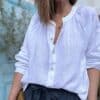 Chemise en lin blanche Albane – Coupe droite ample et boutons nacrés Élégante et confortable, la chemise Albane en lin est un choix parfait pour un look chic et décontracté. Description La chemise en lin blanche Albane est une pièce intemporelle qui se distingue par sa coupe droite ample et son col Mao. Confectionnée dans un lin léger et respirant, elle est idéale pour la saison chaude. Son tissu naturel offre une sensation de confort toute la journée. Les manches longues fermées par des boutons nacrés ajoutent une touche élégante à la chemise. Les boutons nacrés complètent parfaitement le style minimaliste de cette pièce. La taille unique convient aux tailles allant du 36 au 42, s'adaptant ainsi à une large gamme de morphologies. Fabriquée en Italie, cette chemise incarne l'art de la confection italienne avec une attention particulière aux détails et à la qualité des matériaux. Facile à porter, elle peut être associée à un jean pour un look décontracté ou à un pantalon fluide pour une allure plus élégante. Lin léger et respirant pour plus de confort Coupe droite ample pour une silhouette fluide Col Mao pour une touche moderne et chic Manches longues fermées par des boutons nacrés Taille unique (convient du 36 au 42) Fabrication italienne de haute qualité Couleur blanche intemporelle Un essentiel à adopter pour un look élégant et décontracté. Détails produit Coupe : Droite ample Matière : Lin naturel Manches : Longues avec boutons nacrés Col : Mao Boutons : Nacrés Couleur : Blanche Origine : Fabrication italienne Saison : Printemps / Été