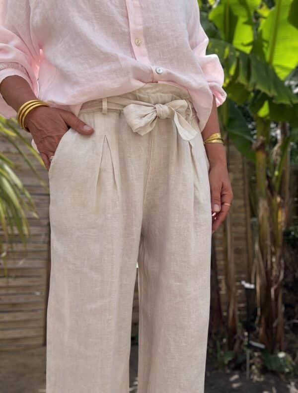 Pantalon femme en lin beige clair - Modèle Pierre Élégance naturelle et confort absolu : découvrez le pantalon Pierre en beige clair. Fabriqué en Italie, il est conçu en lin de qualité supérieure. Coupe droite et fluide Taille haute avec pinces Passants pour ceinture Ceinture amovible assortie incluse Deux poches latérales pratiques Coloris beige clair, doux et lumineux Tissu 100 % lin, respirant et léger Le pantalon Pierre est une pièce facile à associer, idéale pour les saisons douces. Portez-le avec un top ajusté ou une chemise fluide selon vos envies. Conseil taille : Le modèle taille normalement. Prenez votre taille habituelle.
