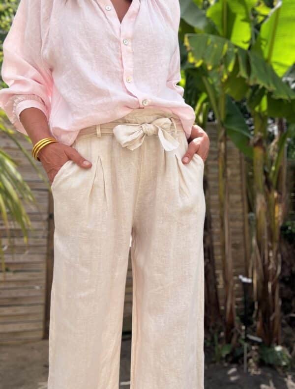 Pantalon femme en lin beige clair - Modèle Pierre Élégance naturelle et confort absolu : découvrez le pantalon Pierre en beige clair. Fabriqué en Italie, il est conçu en lin de qualité supérieure. Coupe droite et fluide Taille haute avec pinces Passants pour ceinture Ceinture amovible assortie incluse Deux poches latérales pratiques Coloris beige clair, doux et lumineux Tissu 100 % lin, respirant et léger Le pantalon Pierre est une pièce facile à associer, idéale pour les saisons douces. Portez-le avec un top ajusté ou une chemise fluide selon vos envies. Conseil taille : Le modèle taille normalement. Prenez votre taille habituelle.