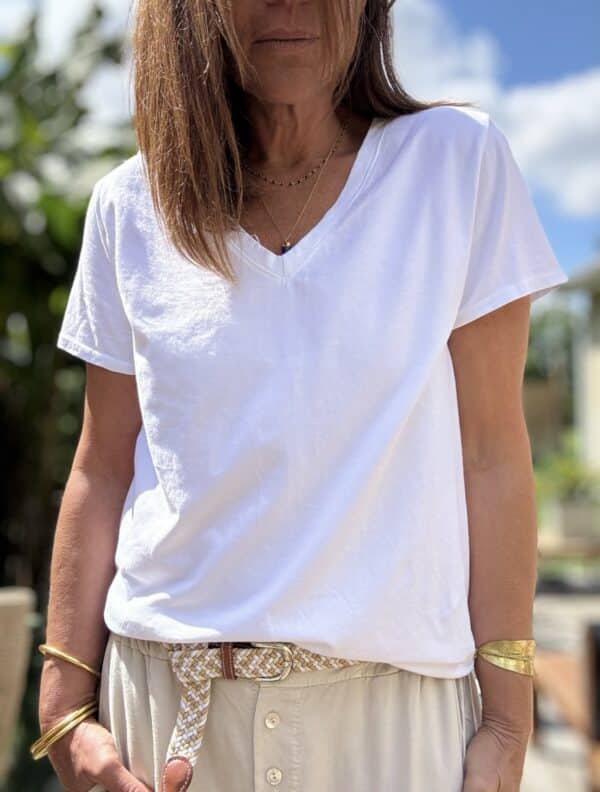 T-shirt col V blanc – Coton et élasthanne Réf. : TSHIRT-V-BLANC En stock T-shirt blanc col V, manches courtes, coupe droite. Composition : 95 % coton, 5 % élasthanne. Taille unique (36 à 42). Fabrication italienne. Description Ce t-shirt blanc est un basique chic et confortable. Son col V met en valeur la silhouette sans effort. La coupe droite et les manches courtes conviennent à toutes. Sa matière douce est composée de 95 % coton et 5 % d’élasthanne. Elle apporte souplesse, confort et respirabilité. La taille unique convient aux morphologies du 36 au 42. Fabriqué en Italie, il allie qualité et finitions soignées. Détails du produit Couleur : Blanc Col : V Manches : Courtes Coupe : Droite Matière : 95 % coton, 5 % élasthanne Taille unique : 36 à 42 Fabrication : Italie Conseil style Associez-le à un jean clair, une jupe fluide ou un pantalon taille haute pour un look simple et efficace. #tshirtblanc #colV #cotoneelasthanne #tailleunique #fabriquéenitalie