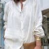 Chemise Romane en lin écru – Taille unique 36-42 Adoptez la version écrue de la chemise Romane. Une pièce douce et lumineuse, confectionnée en Italie dans un lin de qualité. Coupe droite et ample Taille unique : convient du 36 au 42 Col Mao sobre et raffiné Boutons nacrés élégants Découpe devant et dos Manches longues légèrement ballon Finition élastiquée aux poignets Coloris écru, naturel et lumineux 100 % lin respirant Fabrication italienne À porter avec du denim brut, du lin coloré ou une jupe fluide. Une chemise essentielle pour un vestiaire estival et intemporel. Conseil style : Ajoutez des bijoux dorés ou un sac en cuir naturel pour compléter le look.