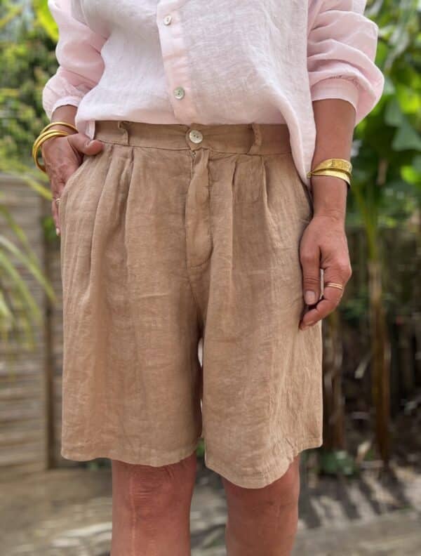 Short femme en lin camel - Modèle Timéo Craquez pour la version camel du short Timéo. Sa coupe ample et sa fabrication italienne en font un indispensable de l’été. Coupe droite et confortable Pinces sur le devant Fermeture zippée avec bouton Passants pour ajouter une ceinture Dos élastiqué pour plus de confort Coloris camel, doux et élégant 100 % lin naturel, léger et respirant Fabrication italienne de qualité Ce short s’associe facilement avec du blanc, du noir ou des tons terracotta. À porter aussi bien en ville qu’en vacances. Conseil taille : Prenez votre taille habituelle. Le modèle taille normalement.