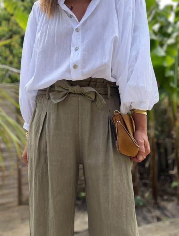 Pantalon femme en lin kaki - Modèle Pierre Fabriqué en Italie, le pantalon Pierre est confectionné en lin de haute qualité. Sa coupe droite et large sublime la silhouette tout en garantissant un confort optimal. Coupe droite et fluide Taille haute avec pinces Passants pour ceinture Ceinture amovible incluse Deux poches latérales pratiques Tissu 100 % lin, léger et respirant Coloris kaki intemporel Ce modèle polyvalent se porte aussi bien en journée qu’en soirée. Associez-le à une blouse élégante ou un t-shirt basique pour un look tout en contraste. Conseil taille : Prenez votre taille habituelle. Le modèle taille normalement.