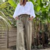 Pantalon femme en lin kaki - Modèle Pierre Fabriqué en Italie, le pantalon Pierre est confectionné en lin de haute qualité. Sa coupe droite et large sublime la silhouette tout en garantissant un confort optimal. Coupe droite et fluide Taille haute avec pinces Passants pour ceinture Ceinture amovible incluse Deux poches latérales pratiques Tissu 100 % lin, léger et respirant Coloris kaki intemporel Ce modèle polyvalent se porte aussi bien en journée qu’en soirée. Associez-le à une blouse élégante ou un t-shirt basique pour un look tout en contraste. Conseil taille : Prenez votre taille habituelle. Le modèle taille normalement.