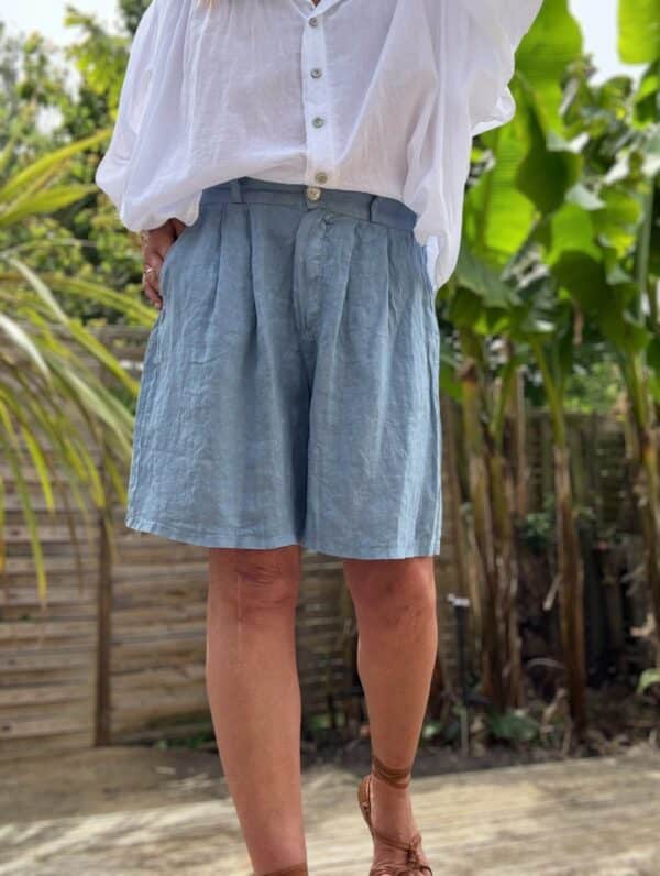 Short femme en lin bleu - Modèle Timéo Élégance et fraîcheur estivale réunies dans le short Timéo. Sa coupe droite et ample épouse le corps tout en liberté. Coupe droite, ample et confortable Pinces à l’avant pour une taille structurée Fermeture zippée + bouton Passants à la taille pour ajouter une ceinture Dos élastiqué pour un ajustement parfait Coloris bleu, profond et lumineux 100 % lin naturel, léger et respirant Fabrication italienne de qualité Idéal pour les beaux jours, ce short s’associe facilement à toutes vos tenues. Portez-le avec un top blanc ou un chemisier coloré. Conseil taille : Le modèle taille normalement. Prenez votre taille habituelle.