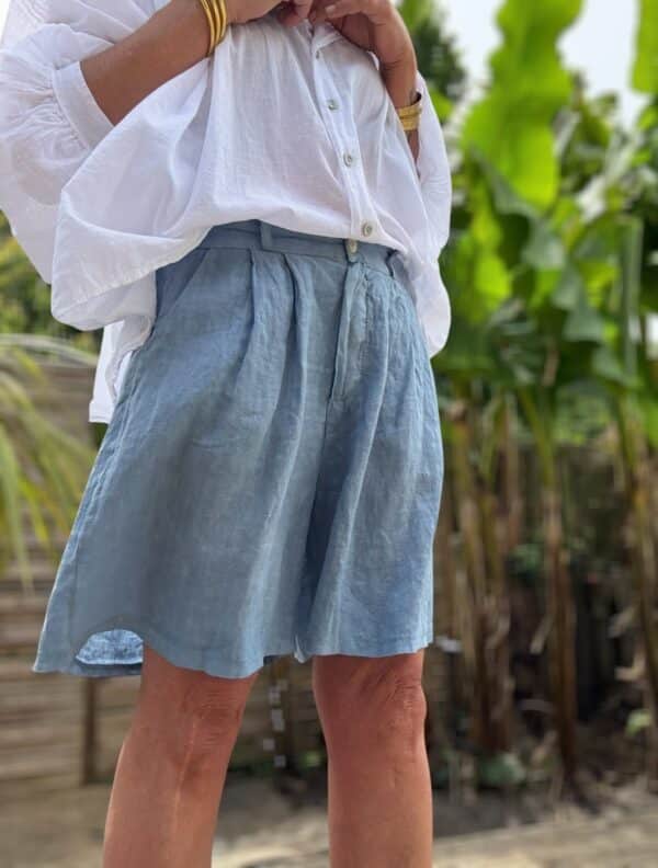 Short femme en lin bleu - Modèle Timéo Élégance et fraîcheur estivale réunies dans le short Timéo. Sa coupe droite et ample épouse le corps tout en liberté. Coupe droite, ample et confortable Pinces à l’avant pour une taille structurée Fermeture zippée + bouton Passants à la taille pour ajouter une ceinture Dos élastiqué pour un ajustement parfait Coloris bleu, profond et lumineux 100 % lin naturel, léger et respirant Fabrication italienne de qualité Idéal pour les beaux jours, ce short s’associe facilement à toutes vos tenues. Portez-le avec un top blanc ou un chemisier coloré. Conseil taille : Le modèle taille normalement. Prenez votre taille habituelle.