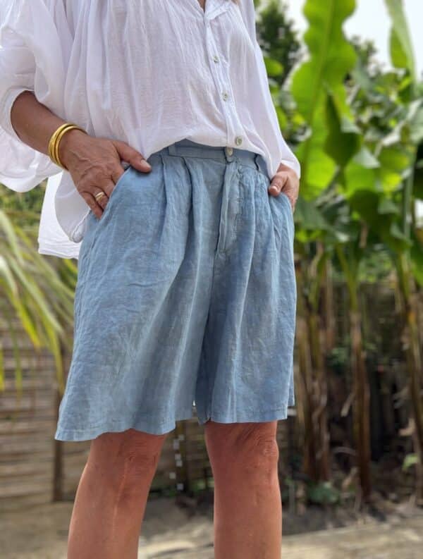 Short femme en lin bleu - Modèle Timéo Élégance et fraîcheur estivale réunies dans le short Timéo. Sa coupe droite et ample épouse le corps tout en liberté. Coupe droite, ample et confortable Pinces à l’avant pour une taille structurée Fermeture zippée + bouton Passants à la taille pour ajouter une ceinture Dos élastiqué pour un ajustement parfait Coloris bleu, profond et lumineux 100 % lin naturel, léger et respirant Fabrication italienne de qualité Idéal pour les beaux jours, ce short s’associe facilement à toutes vos tenues. Portez-le avec un top blanc ou un chemisier coloré. Conseil taille : Le modèle taille normalement. Prenez votre taille habituelle.