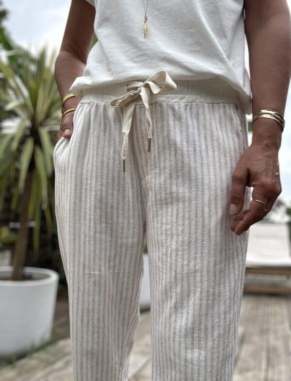 Pantalon Samba – Beige rayé Réf. : SAMBA-BEIGE En stock Pantalon Samba beige rayé. Taille élastique avec lien. Coton-lin. Coupe droite. Taille unique 36 à 40. Fabriqué en Italie. Description Samba, le pantalon beige rayé, léger et agréable à porter. Taille unique 36-40. Coton et lin. Made in Italy. Détails du produit Nom : Samba Couleur : Beige rayé Autre couleur : Existe en kaki Coupe : Droite, légèrement ample Taille : Élastique avec lien à nouer Matière : 70 % coton, 30 % lin Taille unique : Convient du 36 au 40 Poches : Côtés et dos Fabrication : Italie Conseil style À associer avec un débardeur blanc ou une chemise nouée pour un look frais et chic. #Samba #PantalonBeige #MadeInItaly #LookEstival #CotonLin