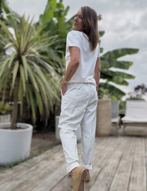 Pantalon Samba – Rayé kaki Réf. : SAMBA-KAKI En stock Pantalon rayé kaki, coupe droite. Taille élastique + lien. Coton et lin. Poches côtés et dos. Taille unique 36 à 40. Description Samba est un pantalon fluide rayé, fabriqué en Italie. Matière légère en coton et lin. Taille unique 36-40. Coupe droite et confortable. Idéal pour l’été. Détails du produit Nom : Samba Couleur : Rayé kaki Autre couleur : Existe en beige Taille : Élastique + lien à nouer Coupe : Droite, légèrement ample Matière : Coton et lin Taille unique : Convient du 36 au 40 Poches : Côtés + dos Fabrication : Italie Conseil style À porter avec un top en lin blanc, des sandales dorées et un panier en osier pour un look d'été parfait. #Samba #PantalonRayé #LookEstival #MadeInItaly #CotonLin