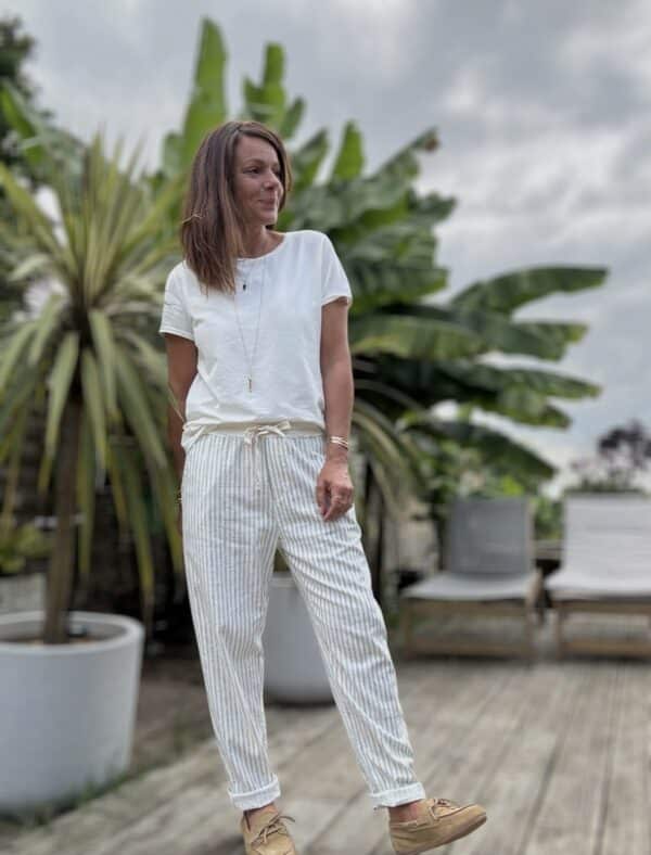 Pantalon Samba – Rayé kaki Réf. : SAMBA-KAKI En stock Pantalon rayé kaki, coupe droite. Taille élastique + lien. Coton et lin. Poches côtés et dos. Taille unique 36 à 40. Description Samba est un pantalon fluide rayé, fabriqué en Italie. Matière légère en coton et lin. Taille unique 36-40. Coupe droite et confortable. Idéal pour l’été. Détails du produit Nom : Samba Couleur : Rayé kaki Autre couleur : Existe en beige Taille : Élastique + lien à nouer Coupe : Droite, légèrement ample Matière : Coton et lin Taille unique : Convient du 36 au 40 Poches : Côtés + dos Fabrication : Italie Conseil style À porter avec un top en lin blanc, des sandales dorées et un panier en osier pour un look d'été parfait. #Samba #PantalonRayé #LookEstival #MadeInItaly #CotonLin