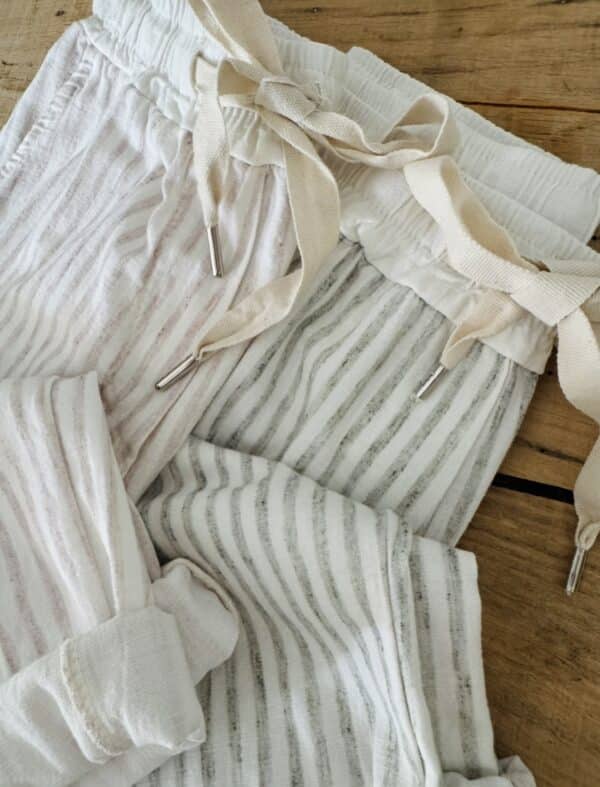 Pantalon Samba – Rayé kaki Réf. : SAMBA-KAKI En stock Pantalon rayé kaki, coupe droite. Taille élastique + lien. Coton et lin. Poches côtés et dos. Taille unique 36 à 40. Description Samba est un pantalon fluide rayé, fabriqué en Italie. Matière légère en coton et lin. Taille unique 36-40. Coupe droite et confortable. Idéal pour l’été. Détails du produit Nom : Samba Couleur : Rayé kaki Autre couleur : Existe en beige Taille : Élastique + lien à nouer Coupe : Droite, légèrement ample Matière : Coton et lin Taille unique : Convient du 36 au 40 Poches : Côtés + dos Fabrication : Italie Conseil style À porter avec un top en lin blanc, des sandales dorées et un panier en osier pour un look d'été parfait. #Samba #PantalonRayé #LookEstival #MadeInItaly #CotonLin