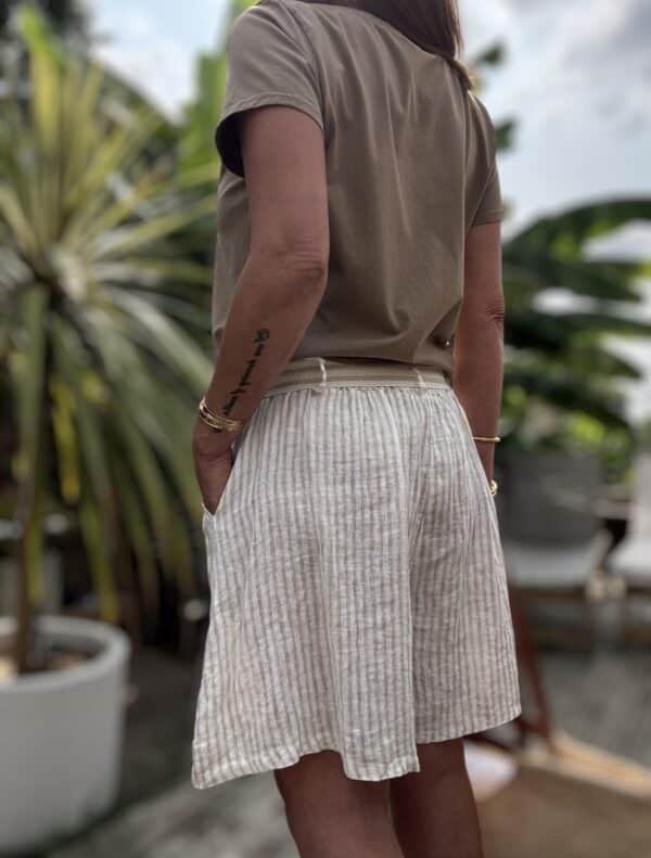 Short Moha – Rayé beige Réf. : MOHA-BEIGE En stock Short rayé beige en lin, taille élastique avec ceinture à nouer. Coupe ample. Taille unique 36-40. Fabrication italienne. Description Le short Moha rayé beige est fluide et léger. En lin, coupe ample, taille élastique. Poches côtés. Made in Italy. Détails du produit Nom : Moha Couleur : Rayé beige Coupe : Ample Taille : Élastique + ceinture Matière : 100 % lin Poches : Côtés Taille unique : Convient du 36 au 40 Fabrication : Italie Conseil style Associez-le à une chemise blanche fluide ou un débardeur ajusté pour un look estival simple et chic. #ShortMoha #LookÉté #LinNaturel #MadeInItaly #ModeResponsable