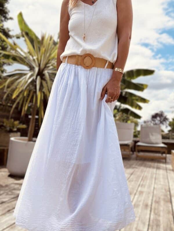 Jupe longue Elena – Blanc Réf. : ELENA-BLANC En stock Jupe longue blanche en voile de coton. Taille élastique. Ceinture incluse. Taille unique 36-42/44. Fabriquée en Italie. Existe en camel et vanille. Description Légère, fluide et élégante, la jupe Elena blanche est votre alliée parfaite pour l’été. Voile de coton, taille unique, ceinture amovible. Détails du produit Nom : Elena Type : Jupe longue Couleur : Blanc Matière : Voile de coton Doublure : Jusqu’au genou Taille : Unique (convient 36 à 42/44) Ceinture : Amovible incluse Fabrication : Italie Autres couleurs : Camel, Vanille Conseil style Associez-la avec un top en lin ou un débardeur fluide pour un look lumineux et naturel. #ElenaBlanche #JupeVoileCoton #LookÉté #MadeInItaly #JupeLongue