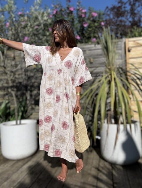 Robe longue PIPA – Beige & motifs framboise La robe PIPA allie légèreté, confort et style pour un été tout en douceur. Coloris : beige Motifs : framboise et beige Matière : double gaze de coton Coupe : longue et ample Col V avec 3 boutons décoratifs Manches courtes Poches sur les côtés Taille unique : convient du 38 au 44 Avec sa coupe fluide et ses détails délicats, la robe PIPA est idéale pour les beaux jours.