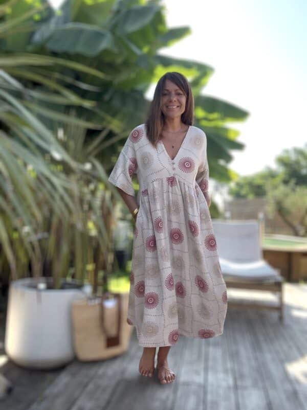 Robe longue PIPA – Beige & motifs framboise La robe PIPA allie légèreté, confort et style pour un été tout en douceur. Coloris : beige Motifs : framboise et beige Matière : double gaze de coton Coupe : longue et ample Col V avec 3 boutons décoratifs Manches courtes Poches sur les côtés Taille unique : convient du 38 au 44 Avec sa coupe fluide et ses détails délicats, la robe PIPA est idéale pour les beaux jours.