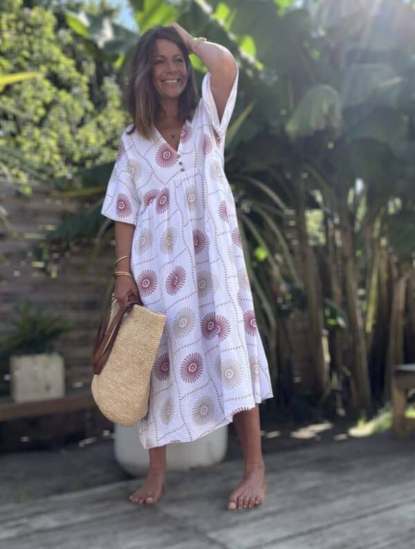 Robe longue PIPA – Blanche & motifs framboise La robe PIPA blanche est un modèle frais, féminin et parfait pour l'été. Coloris : blanc Motifs : framboise et beige Matière : double gaze de coton Coupe : longue, ample et fluide Col V avec 3 boutons décoratifs Manches courtes Poches discrètes sur les côtés Taille unique : convient du 38 au 44 Légère, élégante et agréable à porter, la robe PIPA est votre alliée chic et décontractée de l'été.