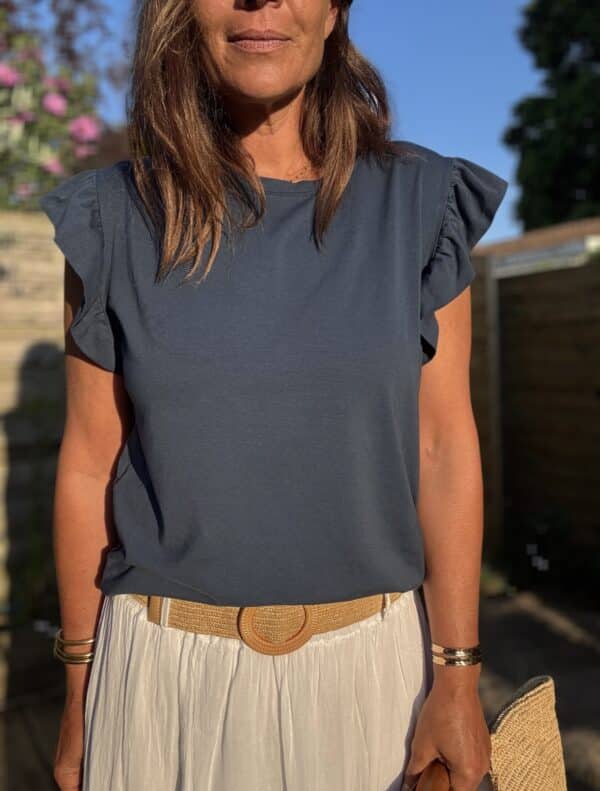 T-shirt Isaée – Marine Isaée en version marine, c’est le t-shirt chic et féminin que l’on porte sans y penser… et qu’on garde longtemps. Couleur : bleu marine (disponible aussi en vanille, camel, jean, terracotta, noir) Matière : coton doux Col : rond Manches : petit volant discret Coupe : droite Taille unique : convient du 36 au 40 Fabrication : italienne Facile à porter, élégant sans effort. Isaée en marine deviendra vite votre nouveau basique préféré.
