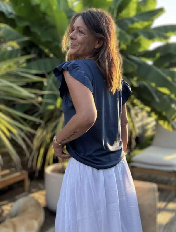 T-shirt Isaée – Marine Isaée en version marine, c’est le t-shirt chic et féminin que l’on porte sans y penser… et qu’on garde longtemps. Couleur : bleu marine (disponible aussi en vanille, camel, jean, terracotta, noir) Matière : coton doux Col : rond Manches : petit volant discret Coupe : droite Taille unique : convient du 36 au 40 Fabrication : italienne Facile à porter, élégant sans effort. Isaée en marine deviendra vite votre nouveau basique préféré.