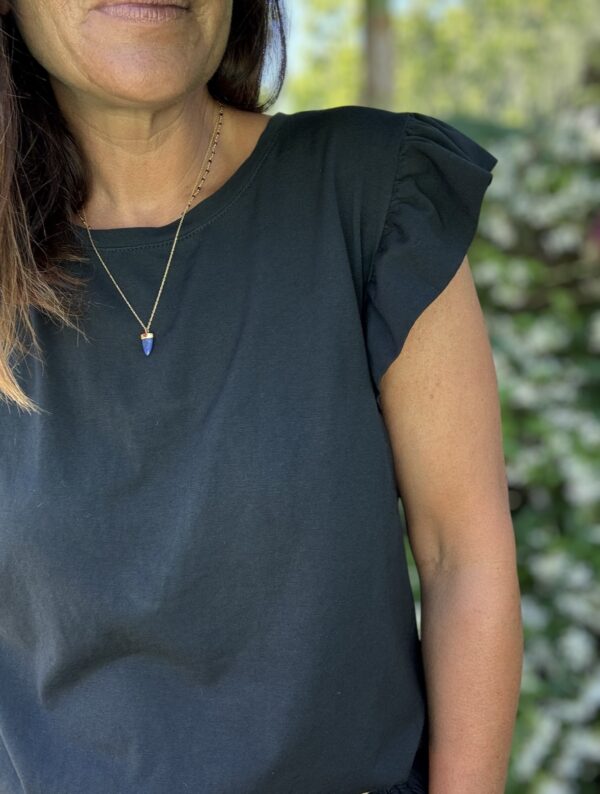 T-shirt Isaée – Noir Isaée revient dans son coloris noir intemporel. Un t-shirt basique, chic et féminin à avoir absolument. Couleur : noir (aussi disponible en vanille, camel, jean, marine, terracotta) Matière : coton doux Col : rond Manches : petit volant discret Coupe : droite Taille unique : convient du 36 au 40 Fabrication : italienne Une pièce qui allie élégance et confort. À porter au quotidien ou pour une allure plus habillée.