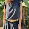 T-shirt Isaée – Noir Isaée revient dans son coloris noir intemporel. Un t-shirt basique, chic et féminin à avoir absolument. Couleur : noir (aussi disponible en vanille, camel, jean, marine, terracotta) Matière : coton doux Col : rond Manches : petit volant discret Coupe : droite Taille unique : convient du 36 au 40 Fabrication : italienne Une pièce qui allie élégance et confort. À porter au quotidien ou pour une allure plus habillée.
