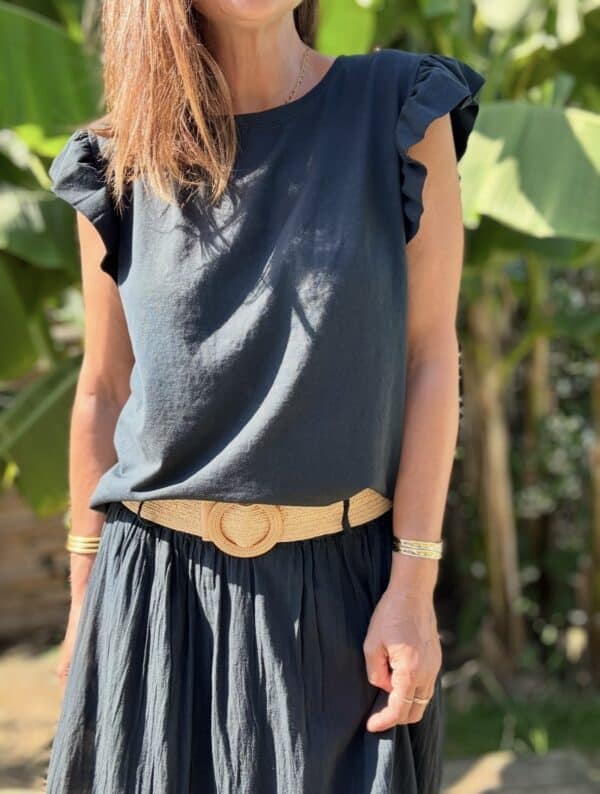 T-shirt Isaée – Noir Isaée revient dans son coloris noir intemporel. Un t-shirt basique, chic et féminin à avoir absolument. Couleur : noir (aussi disponible en vanille, camel, jean, marine, terracotta) Matière : coton doux Col : rond Manches : petit volant discret Coupe : droite Taille unique : convient du 36 au 40 Fabrication : italienne Une pièce qui allie élégance et confort. À porter au quotidien ou pour une allure plus habillée.