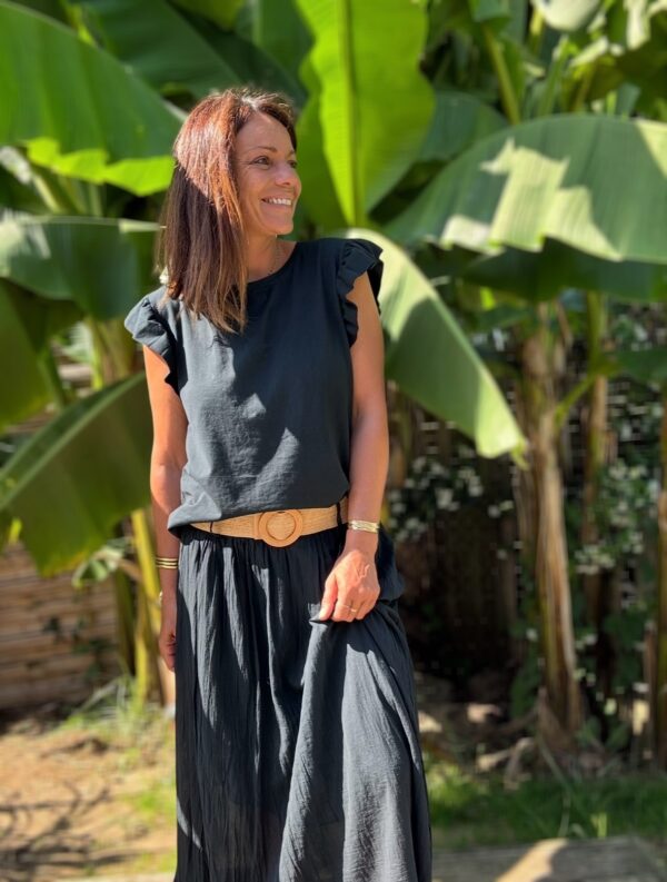 T-shirt Isaée – Noir Isaée revient dans son coloris noir intemporel. Un t-shirt basique, chic et féminin à avoir absolument. Couleur : noir (aussi disponible en vanille, camel, jean, marine, terracotta) Matière : coton doux Col : rond Manches : petit volant discret Coupe : droite Taille unique : convient du 36 au 40 Fabrication : italienne Une pièce qui allie élégance et confort. À porter au quotidien ou pour une allure plus habillée.