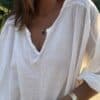 Blouse Agathe – Voile de Coton Blanc La blouse Agathe blanche est une pièce fluide et féminine à avoir dans sa garde-robe. Son voile de coton léger assure confort et élégance. Elle présente une coupe oversize flatteuse et un col V orné de dentelle, pour une touche romantique. Les manches 3/4, finies par un élastique discret, ajoutent de la souplesse au mouvement. La taille unique convient aux morphologies du 38 au 44. Fabriquée avec soin en Italie, cette blouse allie qualité et légèreté. Coloris : blanc Matière : voile de coton Col V avec finition dentelle Manches trois quarts avec élastique Coupe oversize Taille unique : convient du 38 au 44 Fabriquée en Italie