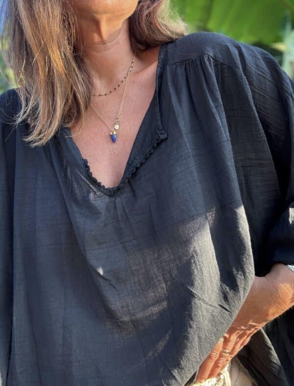 Blouse Agathe – Voile de Coton Noir La blouse Agathe est un vrai coup de cœur. Son voile de coton léger assure un confort absolu en toute saison. Sa coupe oversize apporte fluidité et élégance. Le col V est sublimé par une dentelle de coton délicate. Les manches 3/4 se terminent par un élastique souple, pour un tombé impeccable. Elle convient à une taille unique (38 à 44). Chaque pièce est fabriquée en Italie, avec soin et qualité. Coloris : noir Matière : voile de coton Col V avec finition dentelle Manches trois quarts avec élastique Coupe oversize Taille unique : convient du 38 au 44 Fabriquée en Italie