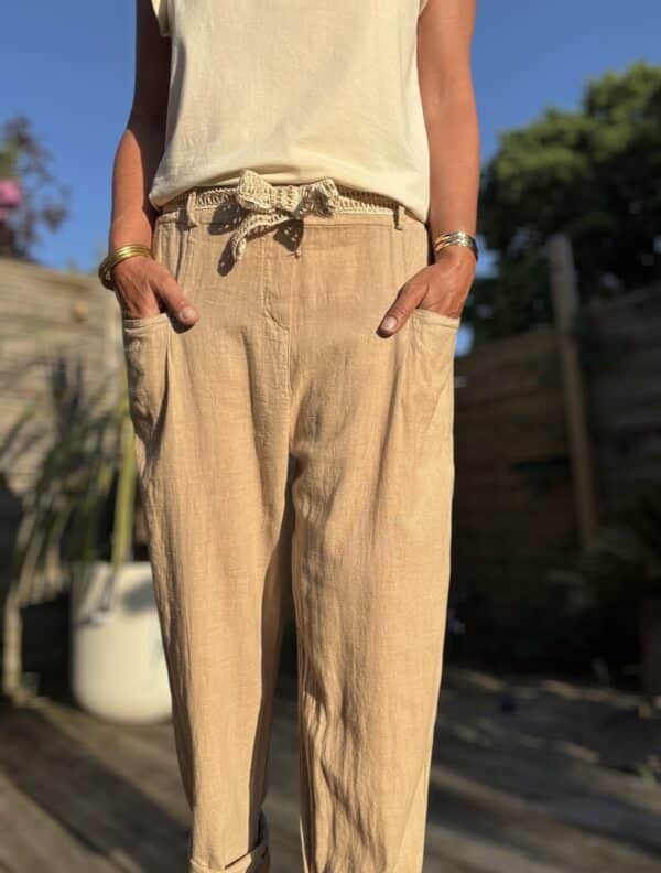 Azélie – Pantalon Camel Léger en Lin et Coton Découvrez Azeli, le pantalon camel pensé pour l’été. Confectionné en 50% coton et 50% lin, il séduit par sa légèreté et son tombé fluide. Sa coupe droite ample convient à toutes les silhouettes. La taille élastique assure confort et maintien sans serrer. En bonus, une ceinture amovible en jute et coton pour un look naturel et raffiné. Ce pantalon dispose de poches pratiques à l’avant et à l’arrière. Sa taille unique convient du 36 au 42. Il est fabriqué en Italie, avec soin et exigence. À associer avec un top léger, un débardeur ou une chemise rentrée. Idéal en ville comme en vacances. Coloris : camel Matière : 50% coton – 50% lin Ceinture amovible (jute & coton) Taille élastique Coupe droite et ample Taille unique : convient du 36 au 40 Fabriqué en Italie