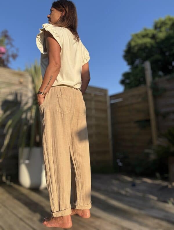 Azélie – Pantalon Camel Léger en Lin et Coton Découvrez Azeli, le pantalon camel pensé pour l’été. Confectionné en 50% coton et 50% lin, il séduit par sa légèreté et son tombé fluide. Sa coupe droite ample convient à toutes les silhouettes. La taille élastique assure confort et maintien sans serrer. En bonus, une ceinture amovible en jute et coton pour un look naturel et raffiné. Ce pantalon dispose de poches pratiques à l’avant et à l’arrière. Sa taille unique convient du 36 au 42. Il est fabriqué en Italie, avec soin et exigence. À associer avec un top léger, un débardeur ou une chemise rentrée. Idéal en ville comme en vacances. Coloris : camel Matière : 50% coton – 50% lin Ceinture amovible (jute & coton) Taille élastique Coupe droite et ample Taille unique : convient du 36 au 40 Fabriqué en Italie