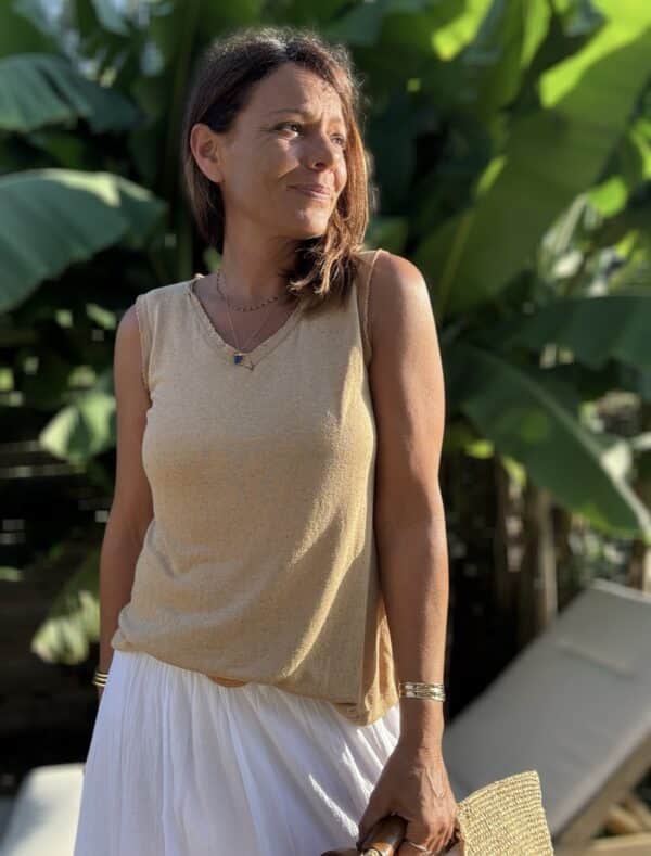 Débardeur JANA – Camel Le débardeur JANA en camel conjugue douceur, légèreté et féminité. Sa matière fluide associe 50 % lin et 50 % viscose pour un confort optimal. Le col V et les emmanchures sont rehaussés de petites franges, offrant un détail bohème chic. La coupe droite, légèrement évasée, flatte toutes les silhouettes. Sa taille unique convient aux morphologies allant du 36 au 40. Ce modèle est fabriqué en Italie dans le respect du savoir-faire textile. Coloris : camel Matière : 50 % lin, 50 % viscose Col V avec franges Franges sur les emmanchures Coupe droite, légèrement évasée Taille unique : convient du 36 au 40 Fabriqué en Italie