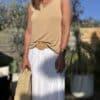 Débardeur JANA – Camel Le débardeur JANA en camel conjugue douceur, légèreté et féminité. Sa matière fluide associe 50 % lin et 50 % viscose pour un confort optimal. Le col V et les emmanchures sont rehaussés de petites franges, offrant un détail bohème chic. La coupe droite, légèrement évasée, flatte toutes les silhouettes. Sa taille unique convient aux morphologies allant du 36 au 40. Ce modèle est fabriqué en Italie dans le respect du savoir-faire textile. Coloris : camel Matière : 50 % lin, 50 % viscose Col V avec franges Franges sur les emmanchures Coupe droite, légèrement évasée Taille unique : convient du 36 au 40 Fabriqué en Italie