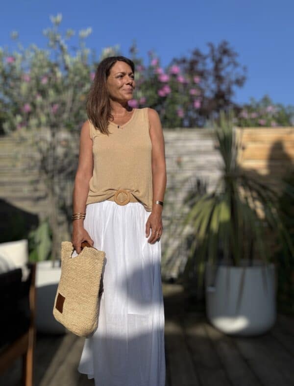 Débardeur JANA – Camel Le débardeur JANA en camel conjugue douceur, légèreté et féminité. Sa matière fluide associe 50 % lin et 50 % viscose pour un confort optimal. Le col V et les emmanchures sont rehaussés de petites franges, offrant un détail bohème chic. La coupe droite, légèrement évasée, flatte toutes les silhouettes. Sa taille unique convient aux morphologies allant du 36 au 40. Ce modèle est fabriqué en Italie dans le respect du savoir-faire textile. Coloris : camel Matière : 50 % lin, 50 % viscose Col V avec franges Franges sur les emmanchures Coupe droite, légèrement évasée Taille unique : convient du 36 au 40 Fabriqué en Italie