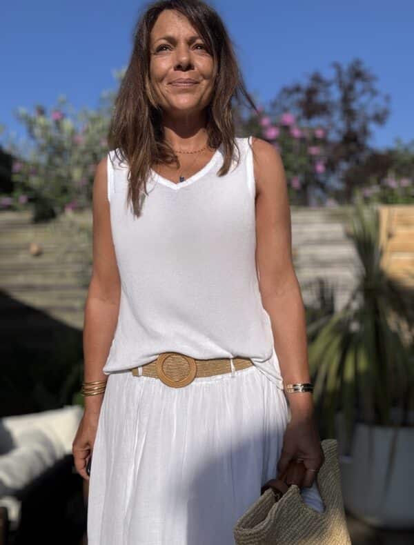 Débardeur JANA – Blanc Le débardeur JANA est un basique estival revisité avec élégance. Sa matière légère en 50 % lin et 50 % viscose apporte une douceur incomparable. Le col V est décoré de petites franges délicates, également présentes sur les emmanchures. La coupe droite, légèrement évasée, flatte toutes les morphologies. La taille unique convient parfaitement aux silhouettes du 36 au 40. Cette pièce est fabriquée en Italie avec soin. Coloris : blanc Matière : 50 % lin, 50 % viscose Col V avec franges Franges sur les emmanchures Coupe droite, légèrement évasée Taille unique : convient du 36 au 40 Fabriqué en Italie