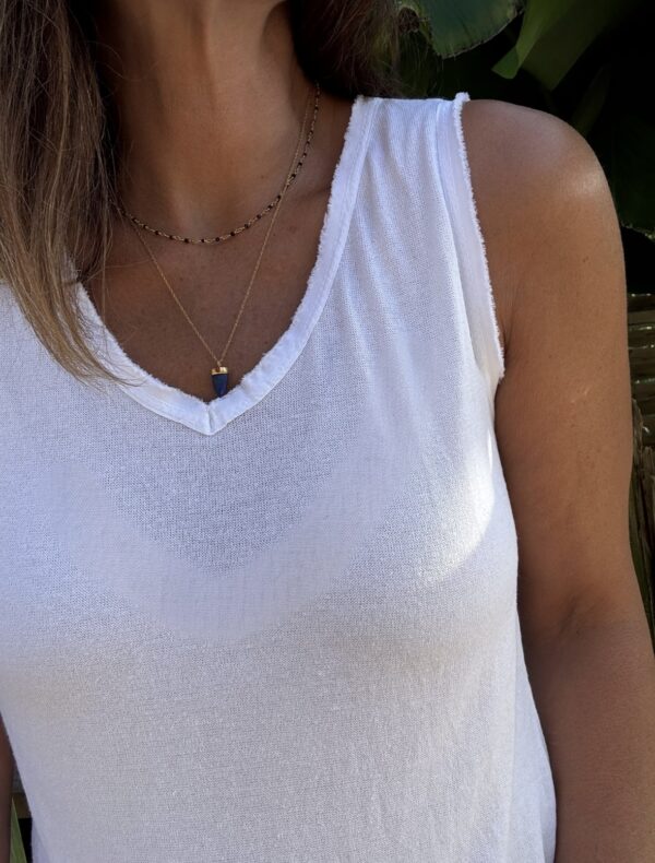 Débardeur JANA – Blanc Le débardeur JANA est un basique estival revisité avec élégance. Sa matière légère en 50 % lin et 50 % viscose apporte une douceur incomparable. Le col V est décoré de petites franges délicates, également présentes sur les emmanchures. La coupe droite, légèrement évasée, flatte toutes les morphologies. La taille unique convient parfaitement aux silhouettes du 36 au 40. Cette pièce est fabriquée en Italie avec soin. Coloris : blanc Matière : 50 % lin, 50 % viscose Col V avec franges Franges sur les emmanchures Coupe droite, légèrement évasée Taille unique : convient du 36 au 40 Fabriqué en Italie