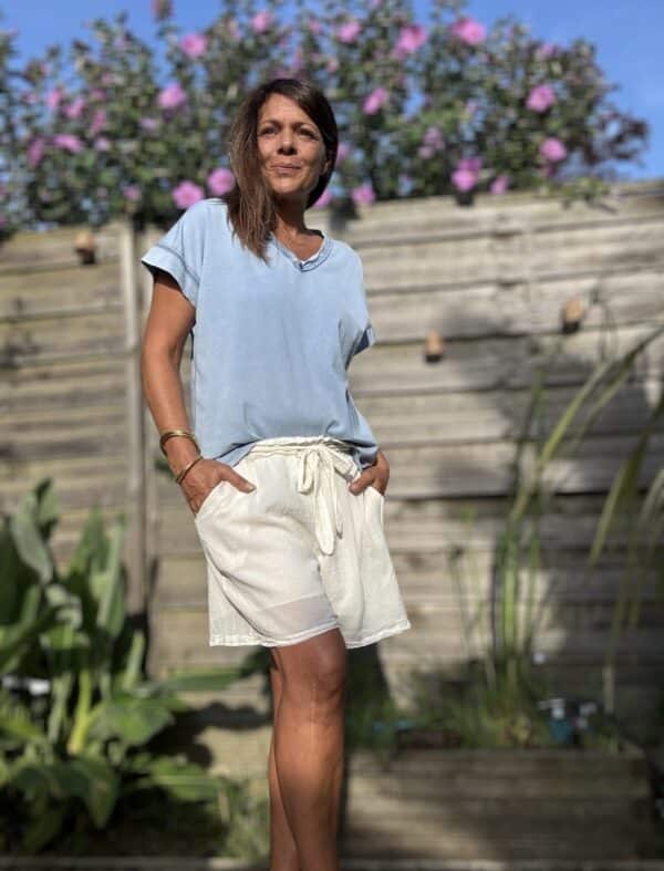 Short SANA – Coloris écru Le short SANA écru, en voile de coton doublé coloré, conjugue élégance et confort pour l’été. Voile de coton doublé, léger et doux Coupe ample et féminine Taille unique (36 à 42) Taille élastique avec lien à nouer Poches sur les côtés Coloris écru (également disponible en camel et terracotta) Fabriqué en Italie À associer avec le débardeur JANA ou le t-shirt LIOR pour un look bohème complet. SANA, la pièce bohème-chic indispensable de l’été.