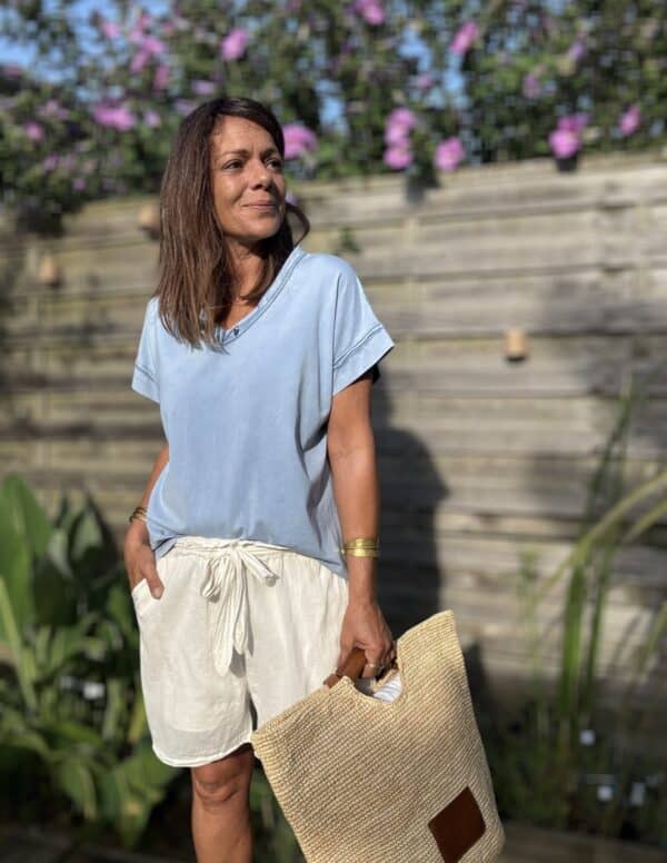 T-shirt LIOR – Jean Clair Le t-shirt LIOR en coloris jean clair est confectionné en Italie dans un coton doux légèrement délavé pour un effet vintage élégant. Sa coupe ample assure un confort optimal et convient à une taille unique allant du 36 au 44. Son col V met en valeur le décolleté tandis que les détails couture sur les manches et le col apportent de la finesse à l’ensemble. Les manches courtes, légèrement tombantes, offrent une silhouette fluide et féminine. Ce coloris jean clair s’accorde parfaitement avec du blanc, du beige, du camel ou des motifs floraux. Pour un style détente ou une tenue citadine, LIOR s’adapte à toutes vos envies. Disponible également en kaki, framboise et camel. Composition : 100% coton Coupe : ample Coloris : jean clair Taille unique : convient du 36 au 44 Fabriqué en Italie