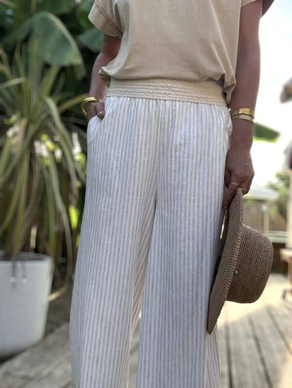 Pantalon Cassia – Rayé beige écru Léger, chic, bohème : découvrez le pantalon Cassia, un essentiel confortable et raffiné. Matière : coton et lin mélangés Rayures beige et écru Coupe large et fluide Taille élastique brodée Poches pratiques sur les côtés Taille unique : convient du 36 au 42 Disponible aussi en kaki Associez-le aux t-shirts Lior pour un look estival 100% bohème-chic. Fabrication italienne 🇮🇹 – signé Les Marques de Lilo