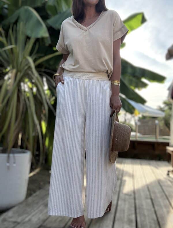 Pantalon Cassia – Rayé beige écru Léger, chic, bohème : découvrez le pantalon Cassia, un essentiel confortable et raffiné. Matière : coton et lin mélangés Rayures beige et écru Coupe large et fluide Taille élastique brodée Poches pratiques sur les côtés Taille unique : convient du 36 au 42 Disponible aussi en kaki Associez-le aux t-shirts Lior pour un look estival 100% bohème-chic. Fabrication italienne 🇮🇹 – signé Les Marques de Lilo