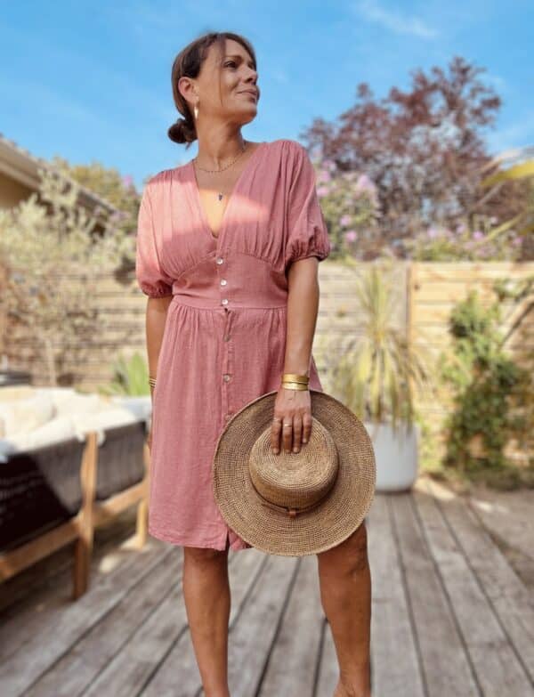 Robe SOLINE – Élégance fluide et féminine Craquez pour la robe Soline, une pièce fluide et légère en viscose et lin, parfaite pour la belle saison. Mix de viscose et lin naturel Coupe mi-longue flatteuse Décolleté plongeant féminin Fermeture intégrale par boutons nacrés Manches courtes avec finition élastiquée Élastique discret au dos pour plus de confort Découpe devant légèrement évasée pour camoufler le ventre Matière respirante et agréable à porter Taille unique (convient du 36 au 40) Fabrication italienne À associer avec des sandales, des bijoux dorés et un panier pour un look bohème-chic sans effort.