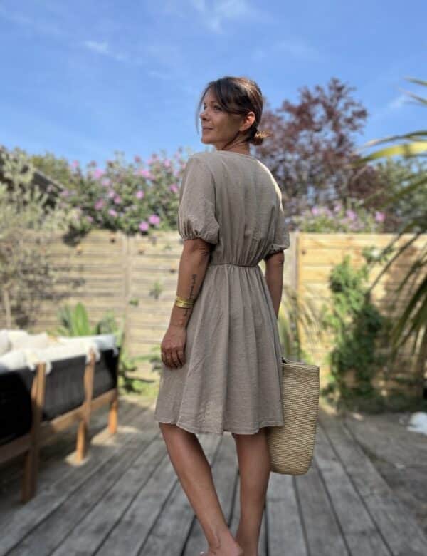Robe mi-longue Soline – Coloris camel Voici la robe Soline en camel, une teinte chaude et naturelle qui sublime la silhouette avec élégance. Composition fluide : viscose & lin Décolleté plongeant délicat Fermeture sur le devant avec boutons nacrés Manches courtes finies par un élastique léger Coupe mi-longue flatteuse et fluide Élastique souple au dos pour plus d’aisance Découpe légèrement plus ample sur le ventre Coloris camel facile à porter et associer Taille unique (du 36 au 40) Confection italienne Parfait avec des sandales dorées, un panier et un chapeau de paille pour un look 100 % bohème-chic.