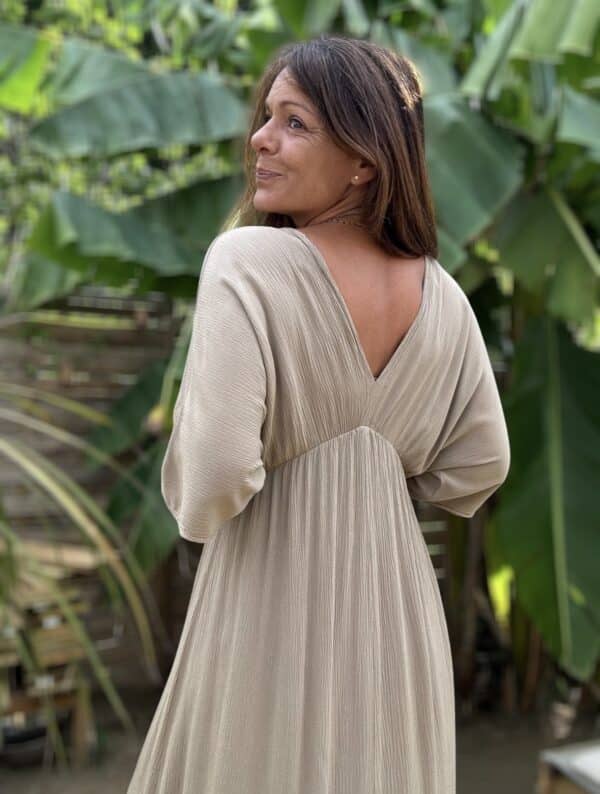 Robe LENAE camel – Longue, fluide et élégante Adoptez la robe LENAE camel, conçue en viscose fluide pour un confort optimal. Sa coupe droite et évasée flatte toutes les silhouettes, tandis que son décolleté en V sublime le port. L'élastique sous la poitrine et le lien à nouer avec pompons permettent un ajustement parfait. Cette robe longue se porte facilement en journée ou en soirée, parfaite pour les beaux jours. Fabriquée en Italie, elle offre une qualité et une finition irréprochables. Disponible en taille unique, elle convient du 36 au 40. Le coloris camel apporte une touche chaude et intemporelle à votre garde-robe. Attention, les stocks sont limités.