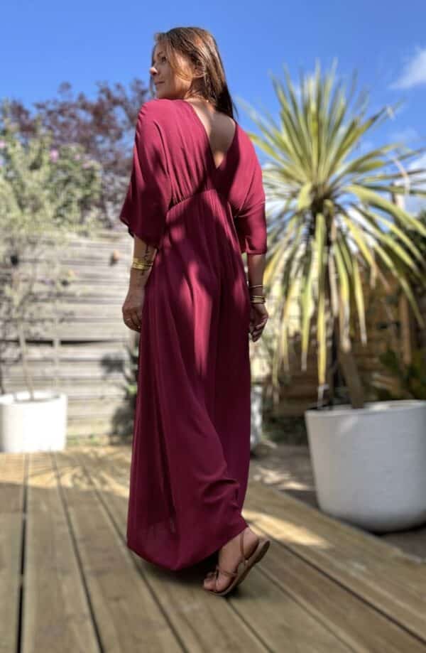 Robe longue fluide bordeaux – LENAE Découvrez la robe LENAE bordeaux, longue et fluide, au tombé naturel et à la couleur profonde. Elle met en valeur chaque silhouette avec douceur et élégance. Sa matière en viscose assure confort, légèreté et fluidité. Elle est idéale pour l'été ou la mi-saison. Le décolleté en V devant et au dos structure la robe avec féminité. L'élasticité fine sous la poitrine souligne subtilement la taille. Un lien à nouer, terminé par de jolis pompons, permet d’ajuster la coupe selon vos envies. Couleur : bordeaux Matière : viscose légère Décolleté : devant et dos Manches : courtes Ceinture : lien à pompons Coupe : droite, légèrement évasée Taille : unique (36 à 40) Fabrication : Italie Associez-la à des accessoires dorés, à une veste en jean ou un gilet léger pour les soirées d'été. LENAE prune, c’est la robe parfaite pour les beaux jours, les soirées, et les instants qui comptent. Edition limitée – dernière chance !