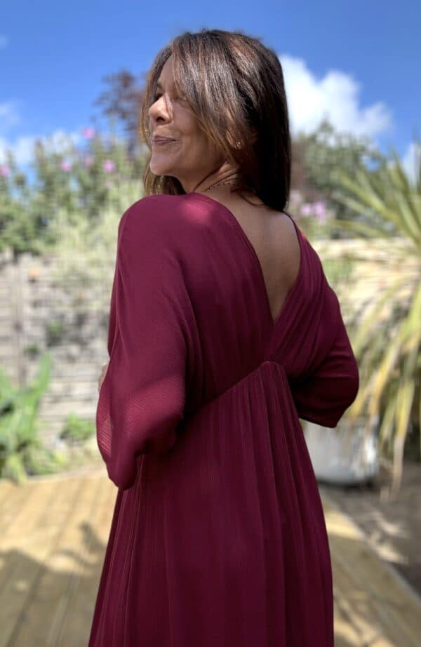 Robe longue fluide bordeaux – LENAE Découvrez la robe LENAE bordeaux, longue et fluide, au tombé naturel et à la couleur profonde. Elle met en valeur chaque silhouette avec douceur et élégance. Sa matière en viscose assure confort, légèreté et fluidité. Elle est idéale pour l'été ou la mi-saison. Le décolleté en V devant et au dos structure la robe avec féminité. L'élasticité fine sous la poitrine souligne subtilement la taille. Un lien à nouer, terminé par de jolis pompons, permet d’ajuster la coupe selon vos envies. Couleur : bordeaux Matière : viscose légère Décolleté : devant et dos Manches : courtes Ceinture : lien à pompons Coupe : droite, légèrement évasée Taille : unique (36 à 40) Fabrication : Italie Associez-la à des accessoires dorés, à une veste en jean ou un gilet léger pour les soirées d'été. LENAE prune, c’est la robe parfaite pour les beaux jours, les soirées, et les instants qui comptent. Edition limitée – dernière chance !