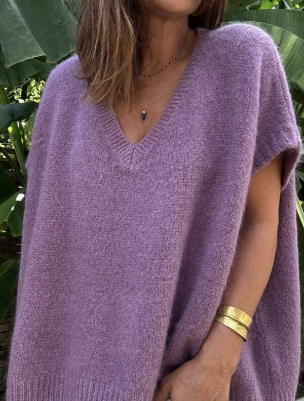 Pull NOE – Coloris doux mauve Le pull NOE revient dans un coloris mauve tendre, aussi doux à porter qu’à regarder. Une teinte poudrée, subtile et féminine, qui réchauffe la silhouette sans jamais l’alourdir. Confectionné en Italie, ce pull sans manche séduit par sa coupe oversize et son col V flatteur. Il contient 30 % de Kidmohair, une fibre naturelle connue pour sa douceur, sa légèreté et sa chaleur douce. Porté seul ou superposé à une robe fluide, NOE structure le look tout en offrant un confort absolu. Il se marie à merveille avec la robe Alba, la robe Enae ou encore la jupe Mira. Taille unique : ce modèle convient du 36 au 44 grâce à sa coupe ample, qui s’adapte à toutes les morphologies sans compromis sur le style. Pull sans manche Coupe oversize Col V féminin Maille douce avec 30 % de Kidmohair Coloris : doux mauve (Doomove) Taille unique (36 à 44) Fabrication italienne 🇮🇹 NOE est le pull doudou par excellence, celui qu’on garde toute l’année pour ses looks doux, élégants et bohème. Doomove, un mauve délicat et poudré, plein de tendresse. Une teinte qui adoucit n’importe quelle silhouette.