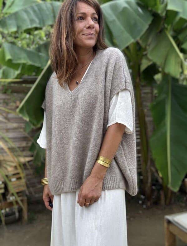Pull sans manche NOE – Coloris Taupe Découvrez le pull NOE, une pièce douce et fluide pensée pour les amoureuses du confort et du style. Ce modèle sans manche séduit par sa coupe oversize, son col V flatteur et surtout, par sa maille moelleuse composée de 30 % de Kidmohair. Sa texture douce réchauffe avec légèreté, tout en laissant respirer la peau. Le coloris Taupe s'impose ici comme un vrai basique chic. Il s’accorde facilement avec des tons neutres ou plus colorés, et accompagne à merveille les pièces de notre collection, comme la robe Alba, la robe Enae ou encore la jupe Mira. Taille unique : ce modèle convient aux morphologies allant du 36 au 44. Sa coupe ample s’adapte naturellement à toutes les silhouettes. Coupe oversize Sans manche Col V Maille douce et chaude (30 % Kidmohair) Coloris : Taupe Fabriqué en Italie Taille unique (36 à 44) Le pull NOE, c’est le pull cocon par excellence : facile à enfiler, agréable à porter, et toujours élégant.