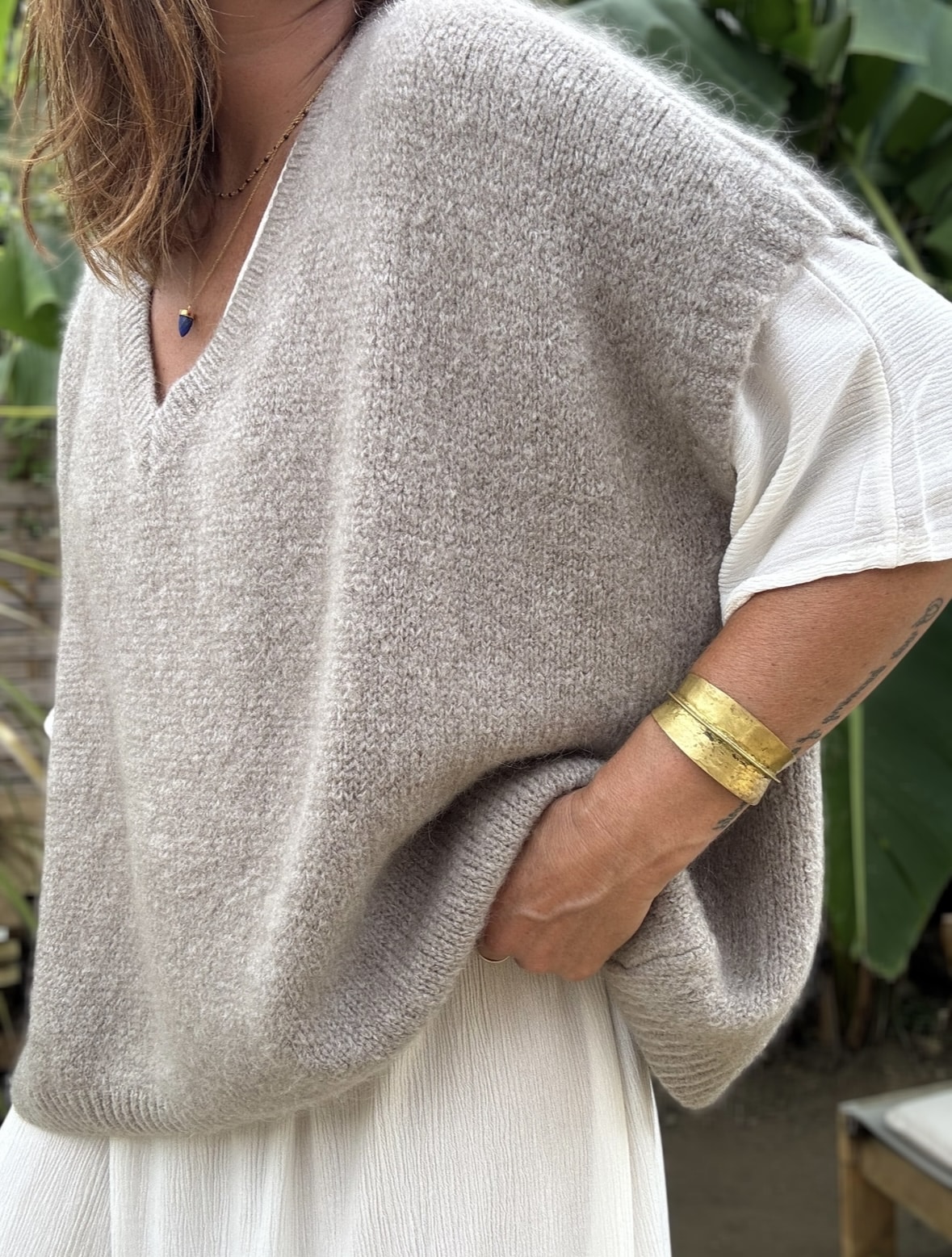 Pull sans manche NOE – Coloris Taupe Découvrez le pull NOE, une pièce douce et fluide pensée pour les amoureuses du confort et du style. Ce modèle sans manche séduit par sa coupe oversize, son col V flatteur et surtout, par sa maille moelleuse composée de 30 % de Kidmohair. Sa texture douce réchauffe avec légèreté, tout en laissant respirer la peau. Le coloris Taupe s'impose ici comme un vrai basique chic. Il s’accorde facilement avec des tons neutres ou plus colorés, et accompagne à merveille les pièces de notre collection, comme la robe Alba, la robe Enae ou encore la jupe Mira. Taille unique : ce modèle convient aux morphologies allant du 36 au 44. Sa coupe ample s’adapte naturellement à toutes les silhouettes. Coupe oversize Sans manche Col V Maille douce et chaude (30 % Kidmohair) Coloris : Taupe Fabriqué en Italie Taille unique (36 à 44) Le pull NOE, c’est le pull cocon par excellence : facile à enfiler, agréable à porter, et toujours élégant.