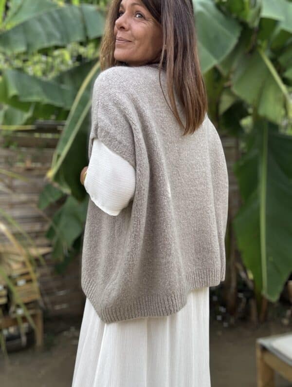 Pull sans manche NOE – Coloris Taupe Découvrez le pull NOE, une pièce douce et fluide pensée pour les amoureuses du confort et du style. Ce modèle sans manche séduit par sa coupe oversize, son col V flatteur et surtout, par sa maille moelleuse composée de 30 % de Kidmohair. Sa texture douce réchauffe avec légèreté, tout en laissant respirer la peau. Le coloris Taupe s'impose ici comme un vrai basique chic. Il s’accorde facilement avec des tons neutres ou plus colorés, et accompagne à merveille les pièces de notre collection, comme la robe Alba, la robe Enae ou encore la jupe Mira. Taille unique : ce modèle convient aux morphologies allant du 36 au 44. Sa coupe ample s’adapte naturellement à toutes les silhouettes. Coupe oversize Sans manche Col V Maille douce et chaude (30 % Kidmohair) Coloris : Taupe Fabriqué en Italie Taille unique (36 à 44) Le pull NOE, c’est le pull cocon par excellence : facile à enfiler, agréable à porter, et toujours élégant.