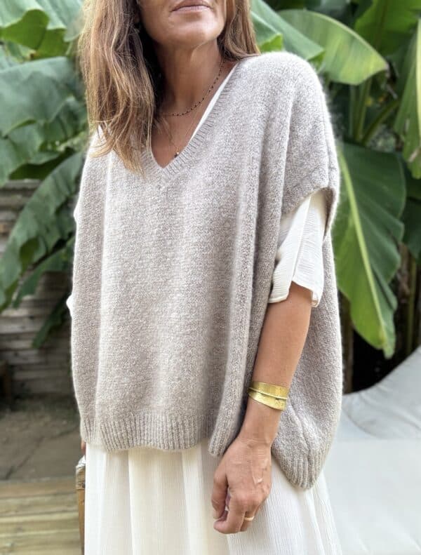 Pull sans manche NOE – Coloris Taupe Découvrez le pull NOE, une pièce douce et fluide pensée pour les amoureuses du confort et du style. Ce modèle sans manche séduit par sa coupe oversize, son col V flatteur et surtout, par sa maille moelleuse composée de 30 % de Kidmohair. Sa texture douce réchauffe avec légèreté, tout en laissant respirer la peau. Le coloris Taupe s'impose ici comme un vrai basique chic. Il s’accorde facilement avec des tons neutres ou plus colorés, et accompagne à merveille les pièces de notre collection, comme la robe Alba, la robe Enae ou encore la jupe Mira. Taille unique : ce modèle convient aux morphologies allant du 36 au 44. Sa coupe ample s’adapte naturellement à toutes les silhouettes. Coupe oversize Sans manche Col V Maille douce et chaude (30 % Kidmohair) Coloris : Taupe Fabriqué en Italie Taille unique (36 à 44) Le pull NOE, c’est le pull cocon par excellence : facile à enfiler, agréable à porter, et toujours élégant.